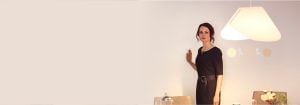 "Woman adjusting bright LED recessed lighting via sleek wall-mounted dimmer, enhancing modern living room's ambiance and energy efficiency."