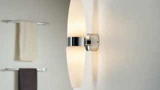 "Modern bathroom featuring sleek LED wall sconce, illuminating minimalist decor and enhancing spa-like ambiance."
