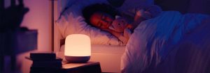 "Smart LED nightlight emitting soft, warm glow as child sleeps peacefully, showcasing customizable bedtime illumination for optimal sleep environment."