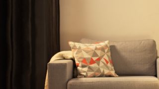 Cozy living room with modern LED table lamp, illuminating gray loveseat and creating warm ambiance for home relaxation.